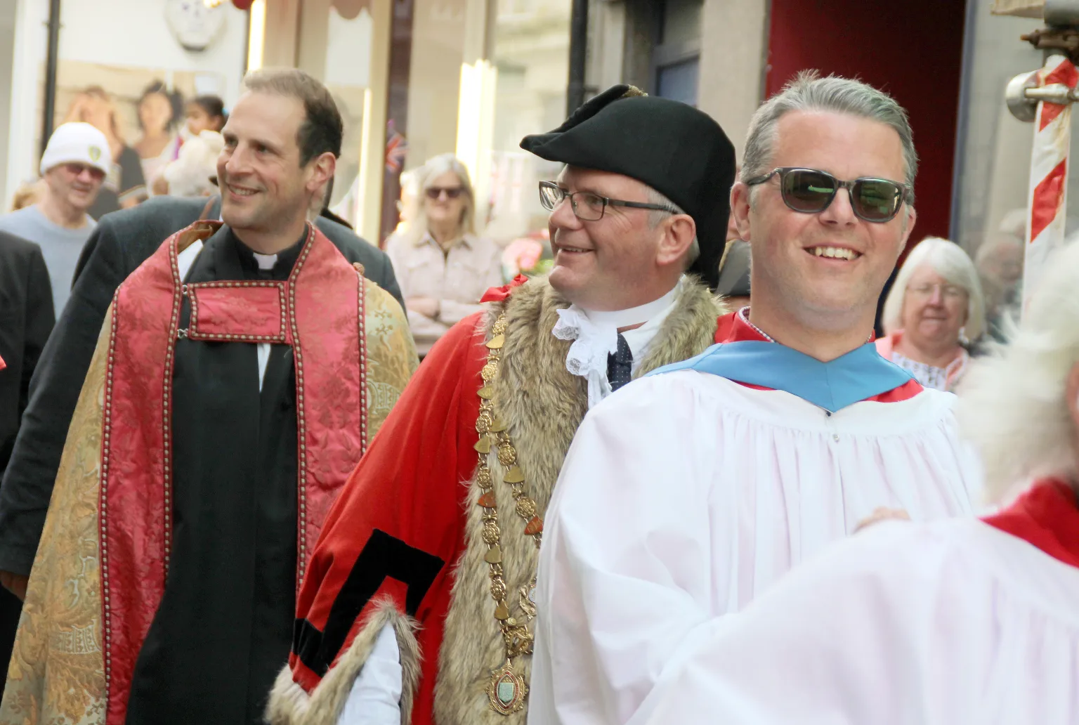 Men smiling and walking in a crowd