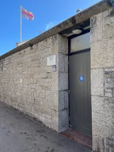 Stone wall with a brown door - public toilet block